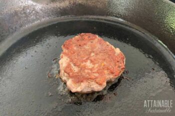 single sausage patty in cast iron