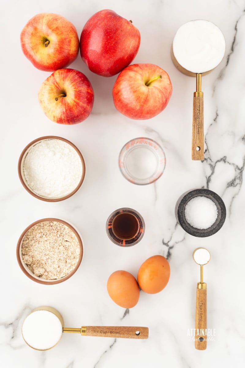 ingredients for apple cake on a marble background.