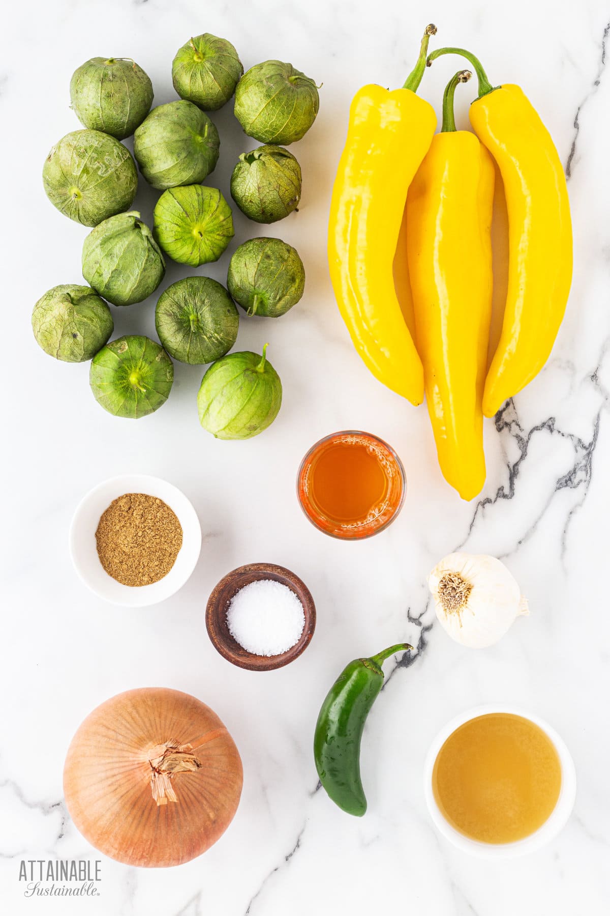 ingredients for roasted tomatillo salsa on a marble background.